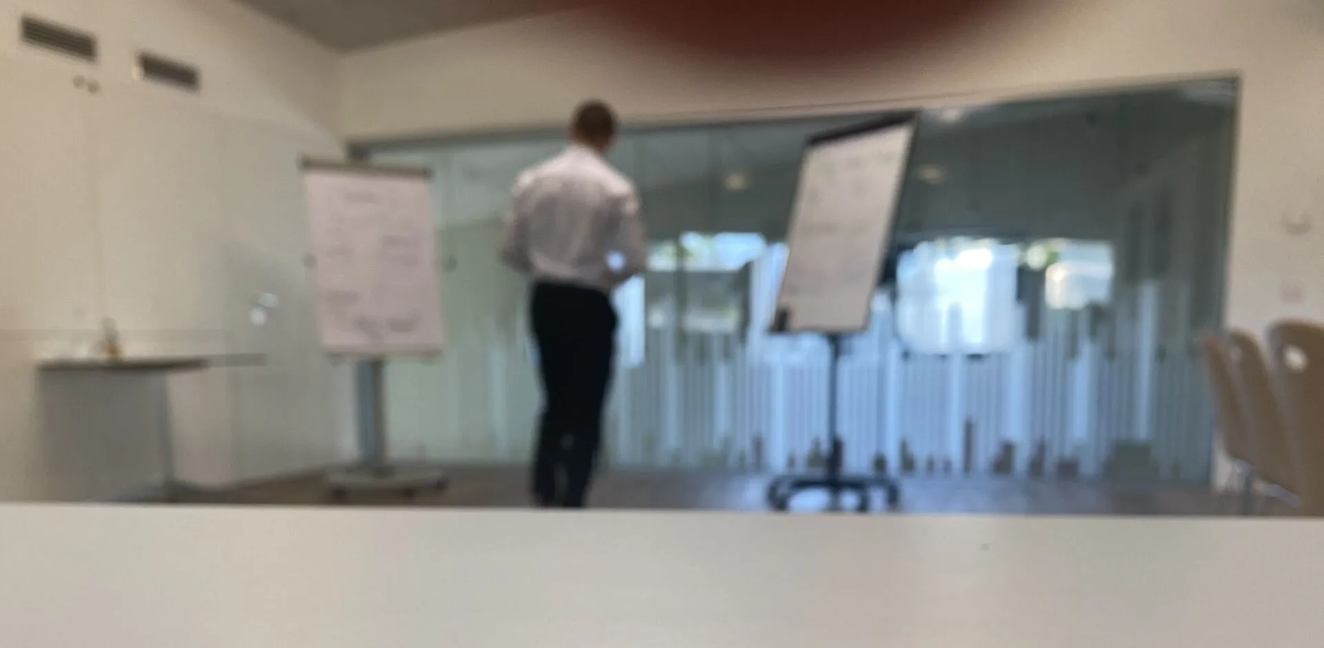 Raphael Lugmayr in a classroom between a blackboard and flipcharts